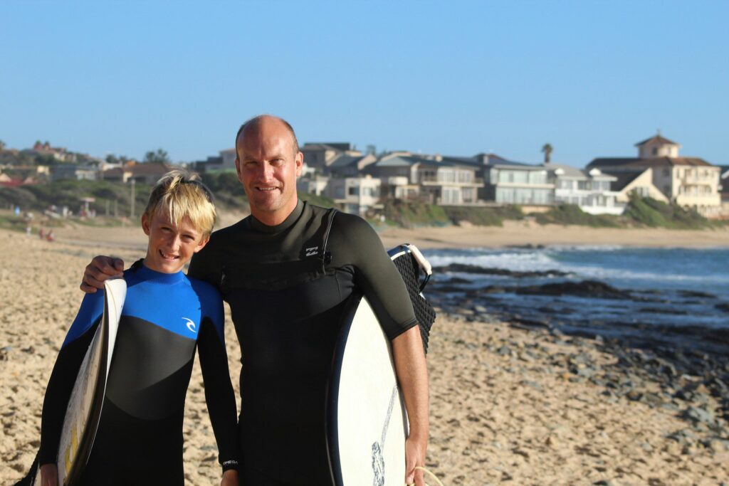 Father and son surfing at a beach