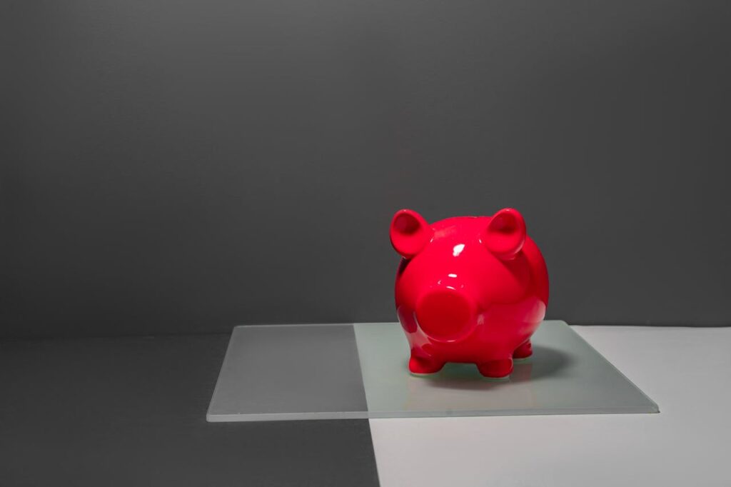 A hot pink piggy bank with a gray background